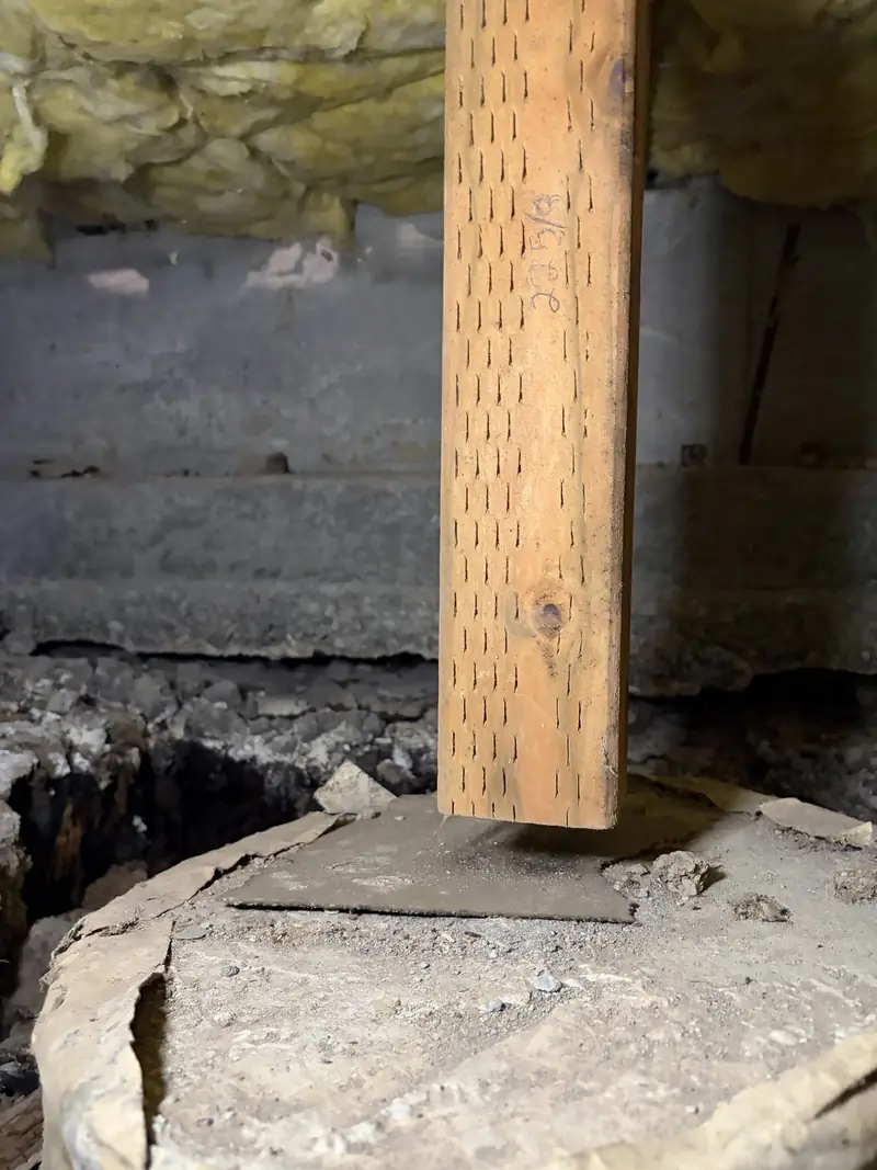 Wood support post on a concrete pier footing in a crawl space