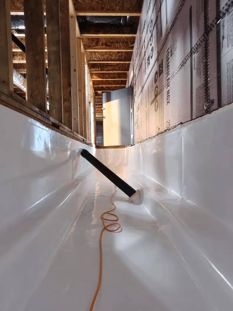 Narrow crawl space section with liner sealed up both walls