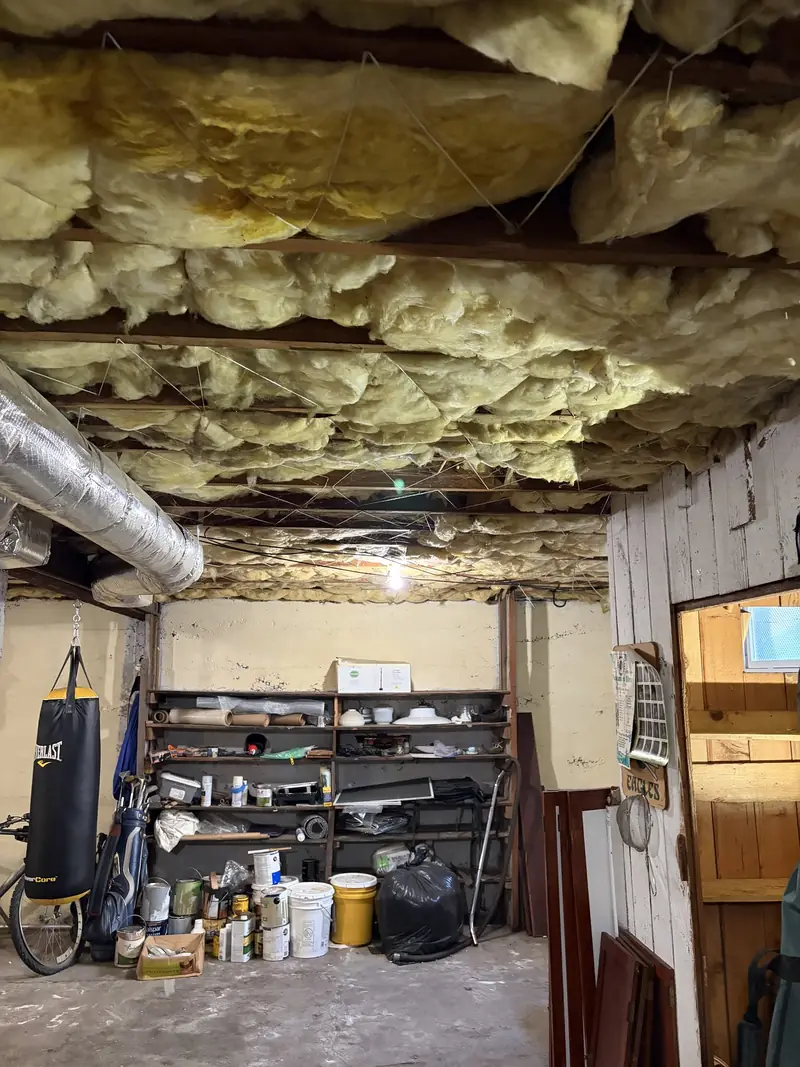 The same floor joists after new fiberglass insulation was installed